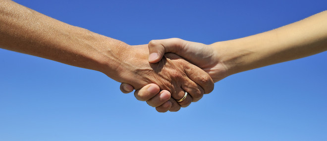 Woman and teenager handshake, on blue sky